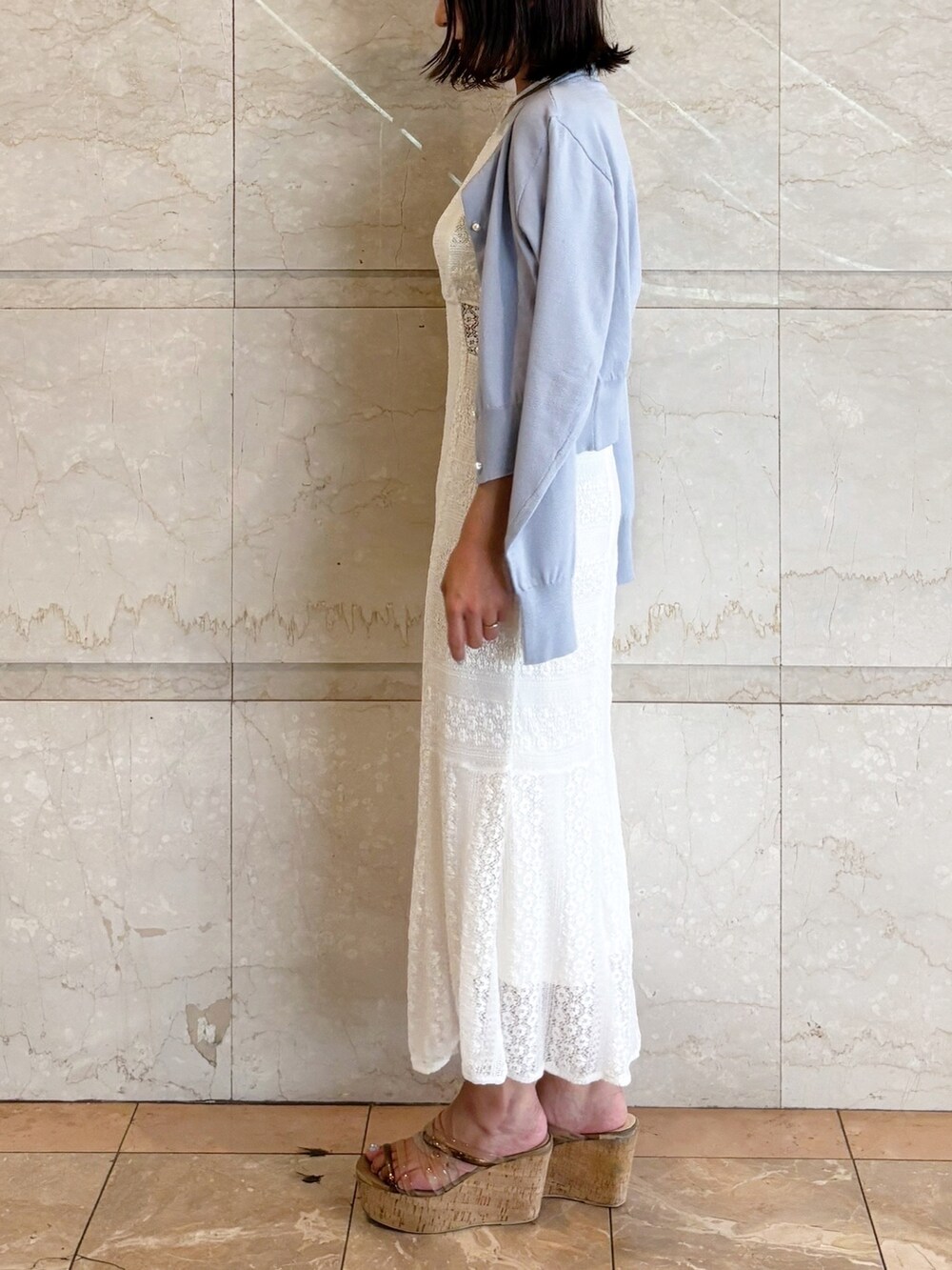 ホワイト系のワンピース、ブラウン系のサンダル、ブルー系のカーディガン/ボレロを着用したレディースの夏コーディネートの5枚目の写真