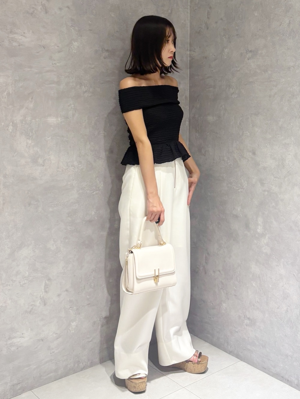 ホワイト系のその他パンツ、ブラウン系のサンダル、ホワイト系のハンドバッグを着用したレディースの春コーディネートの2枚目の写真