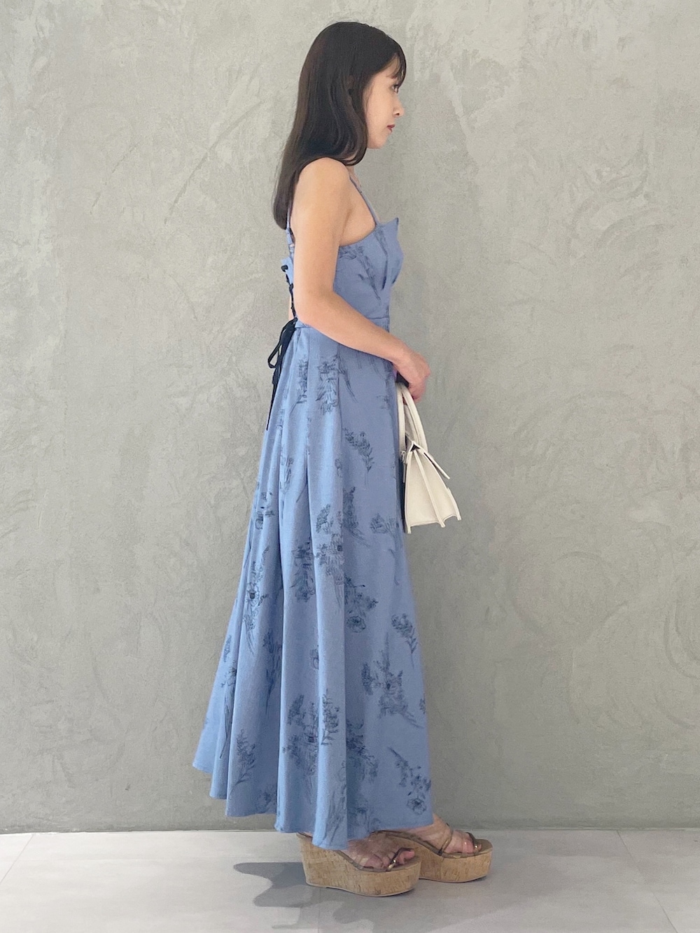 ブルー系のワンピース、ブラウン系のサンダル、ベージュ系のショルダーバッグを着用したレディースの夏コーディネートの3枚目の写真