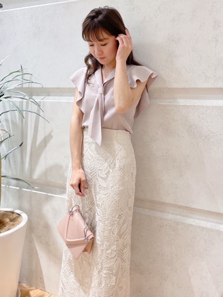 ホワイト系のスカート、ピンク系のショルダーバッグ、グリーン系のサンダルを着用したレディースの春コーディネートの4枚目の写真