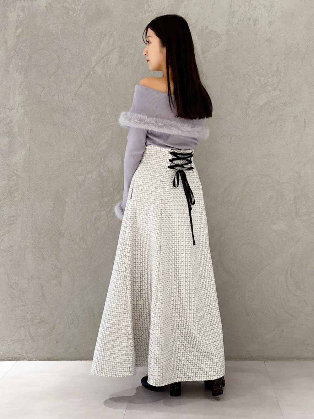 ホワイト系のスカート、ブラック系のブーツ、ホワイト系のショルダーバッグを着用したレディースの冬コーディネートの3枚目の写真