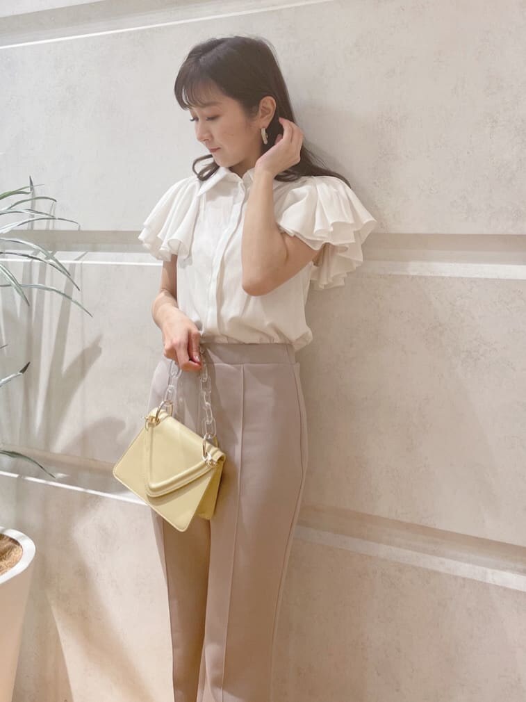 グレー系のその他パンツ、イエロー系のショルダーバッグ、グリーン系のサンダルを着用したレディースの春コーディネートの3枚目の写真