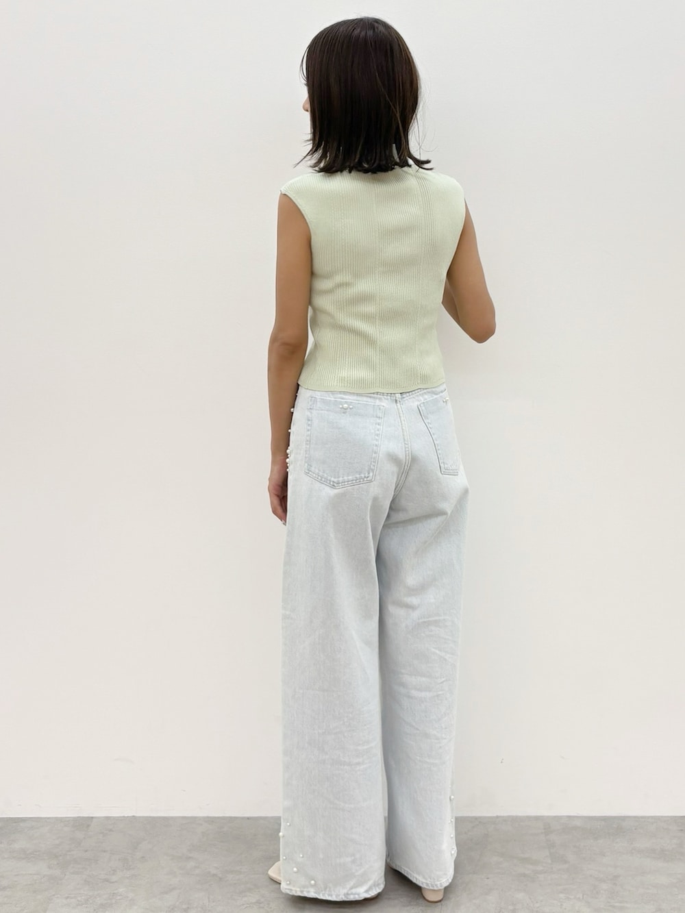 ブルー系のデニムパンツ、グリーン系のニット/セーターを着用したレディースの夏コーディネートの4枚目の写真