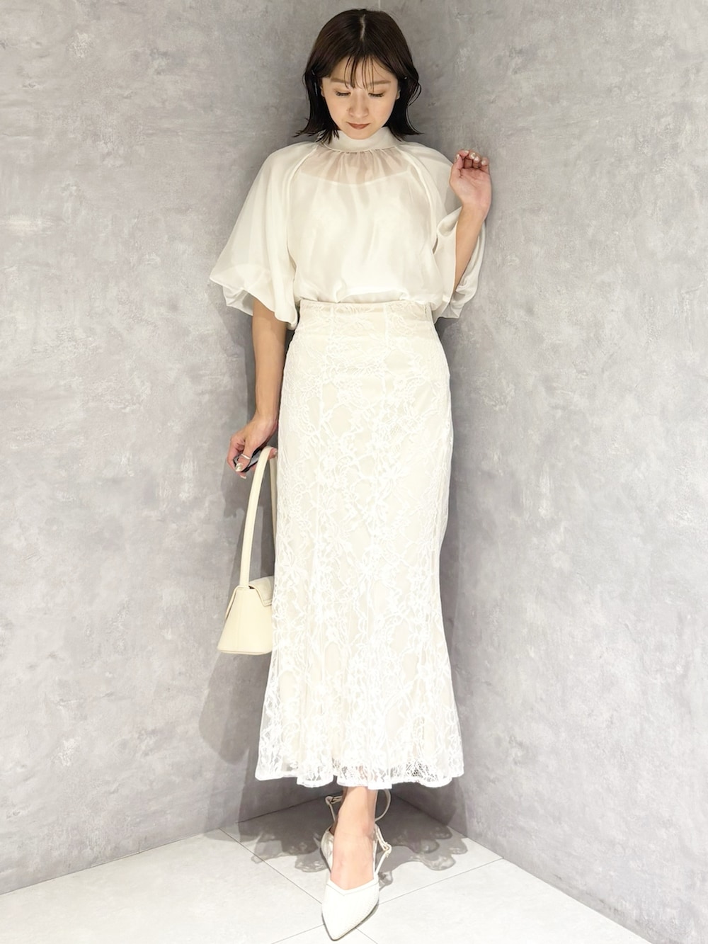 ホワイト系のスカート、ホワイト系のシャツ/ブラウス、ホワイト系のハンドバッグを着用したレディースの春コーディネートの5枚目の写真