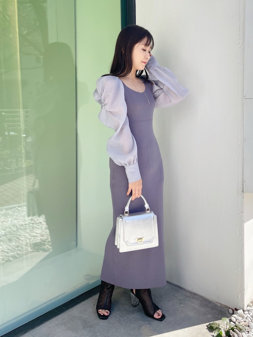 シルバー系のハンドバッグ、ブラック系のブーツ、ブルー系のワンピースを着用したレディースの春コーディネートの4枚目の写真