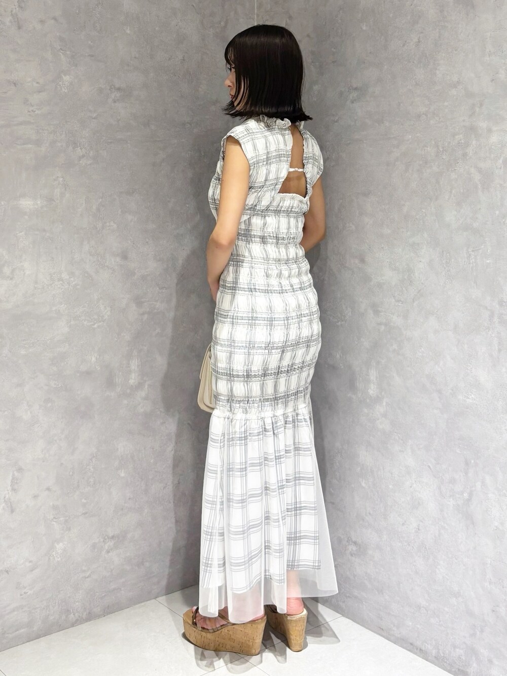 ホワイト系のワンピース、ブラウン系のサンダル、ホワイト系のハンドバッグを着用したレディースの夏コーディネートの3枚目の写真