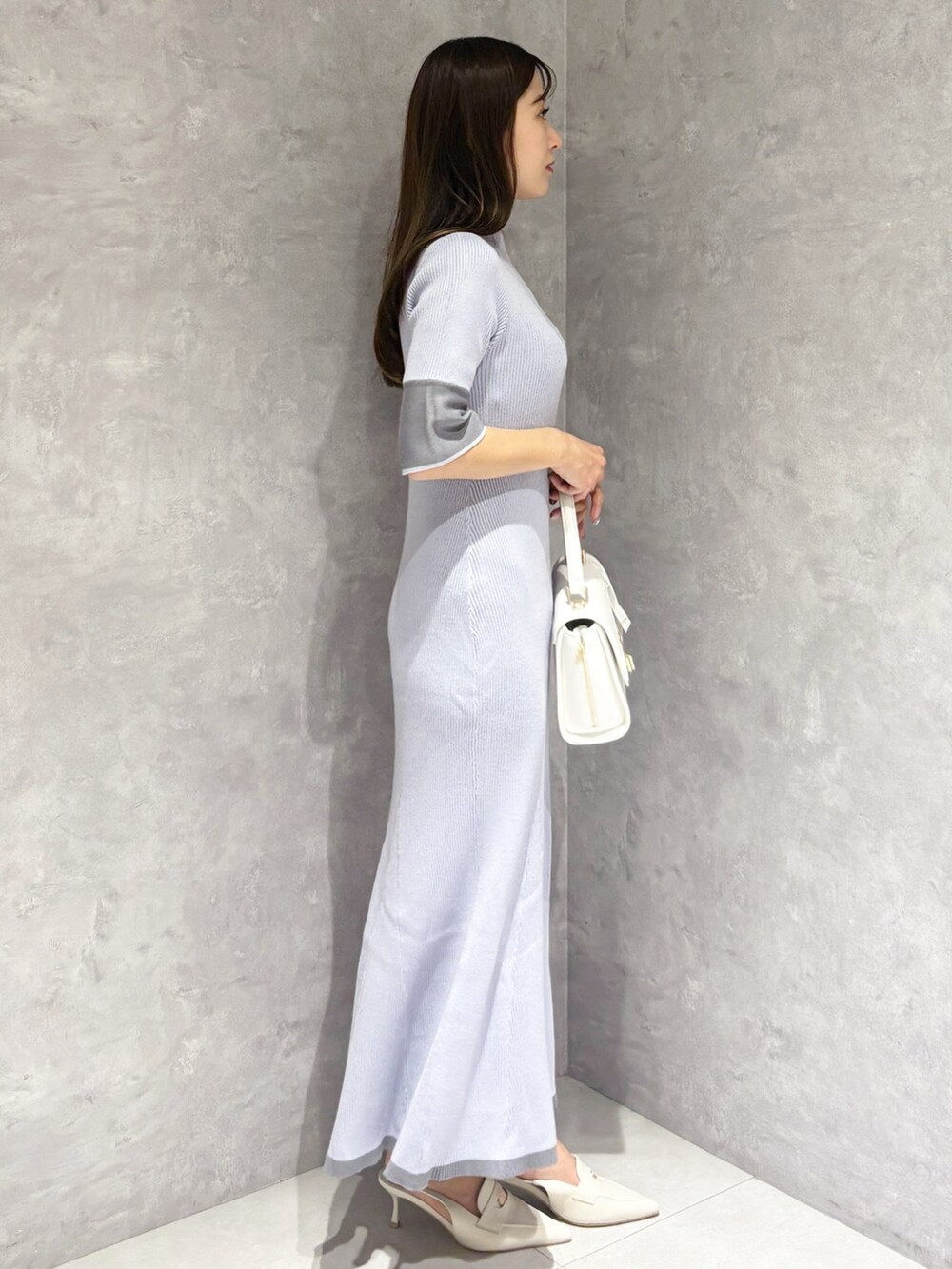 ブルー系のワンピース、ホワイト系のパンプス、ホワイト系のハンドバッグを着用したレディースの春コーディネートの3枚目の写真