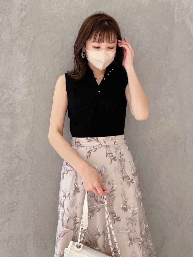 ホワイト系のショルダーバッグ、ブラック系のニット/セーター、ピンク系のスカートを着用したレディースの春コーディネートの2枚目の写真