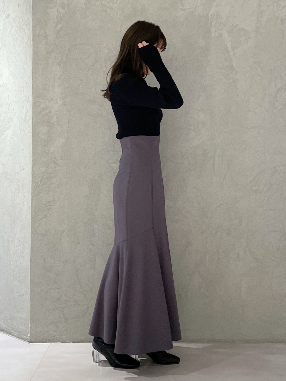 グレー系のスカート、グレー系のニット/セーター、ブラック系のブーツを着用したレディースの冬コーディネートの4枚目の写真