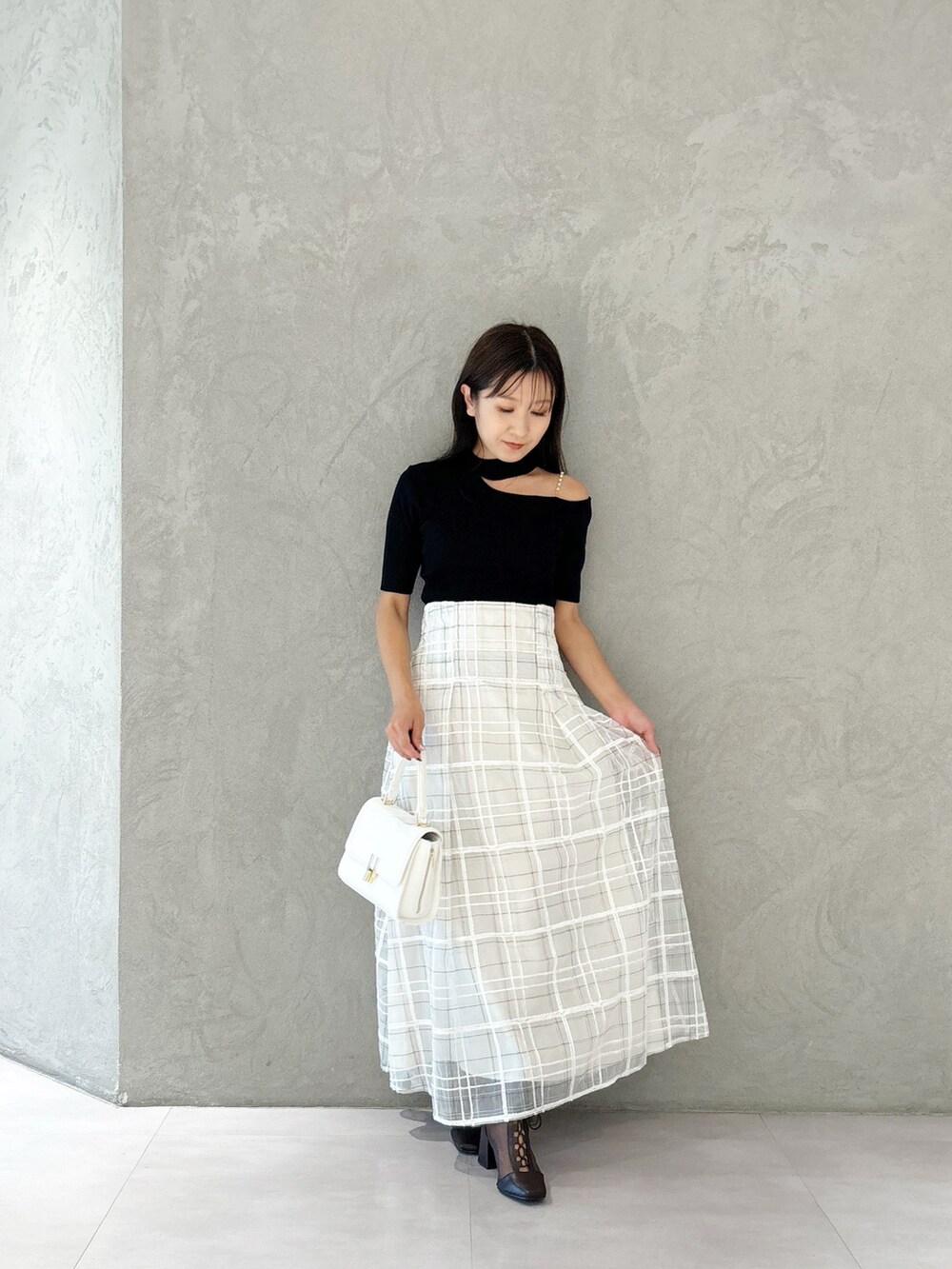 ホワイト系のスカート、ブラウン系のブーツ、ホワイト系のショルダーバッグを着用したレディースの秋コーディネートの6枚目の写真