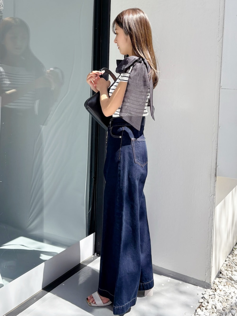 ブルー系のデニムパンツ、その他のニット/セーター、ホワイト系のサンダルを着用したレディースの夏コーディネートの5枚目の写真