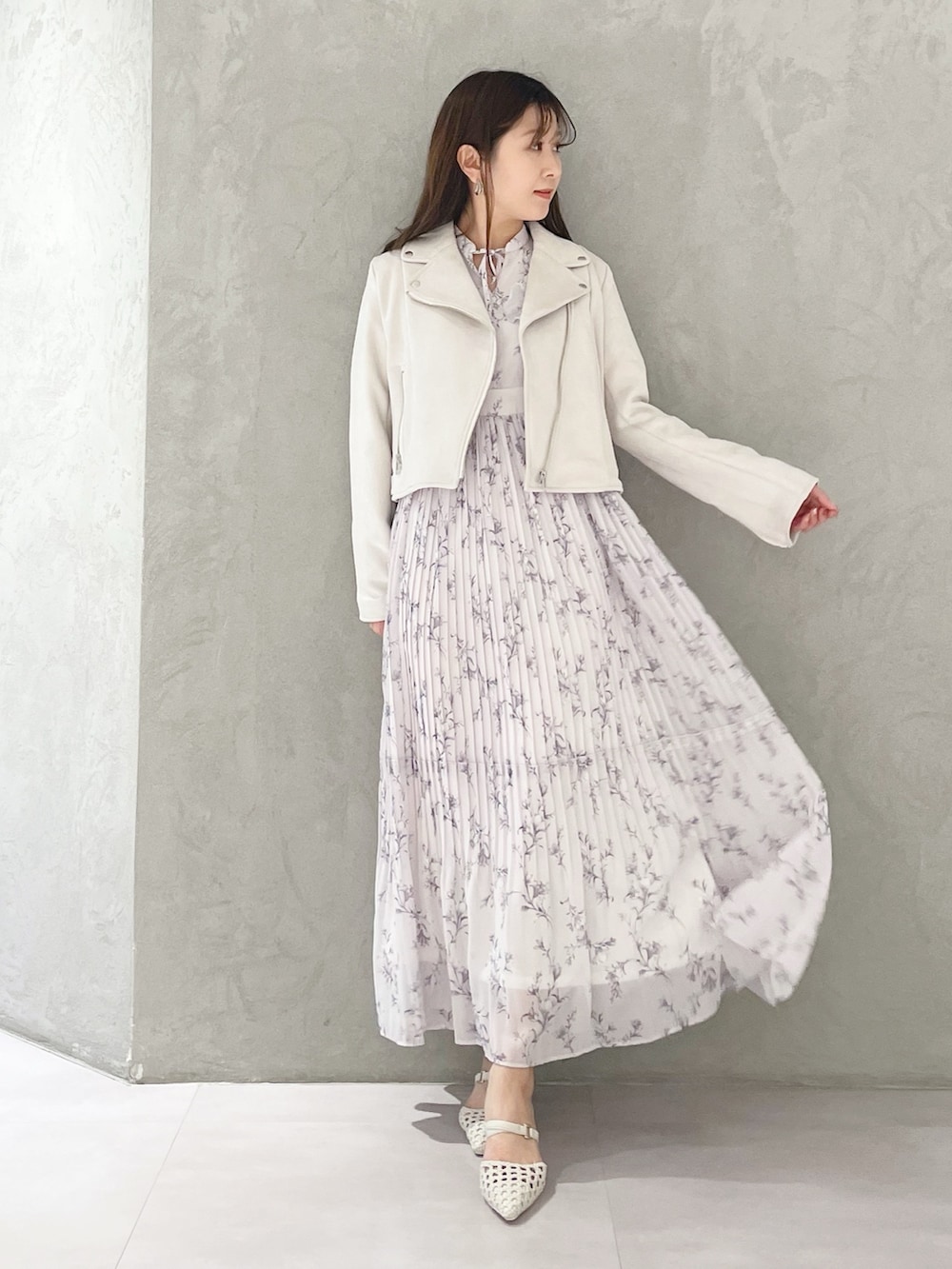 ピンク系のワンピース、ホワイト系のパンプス、ホワイト系のライダースジャケットを着用したレディースの春コーディネートの5枚目の写真