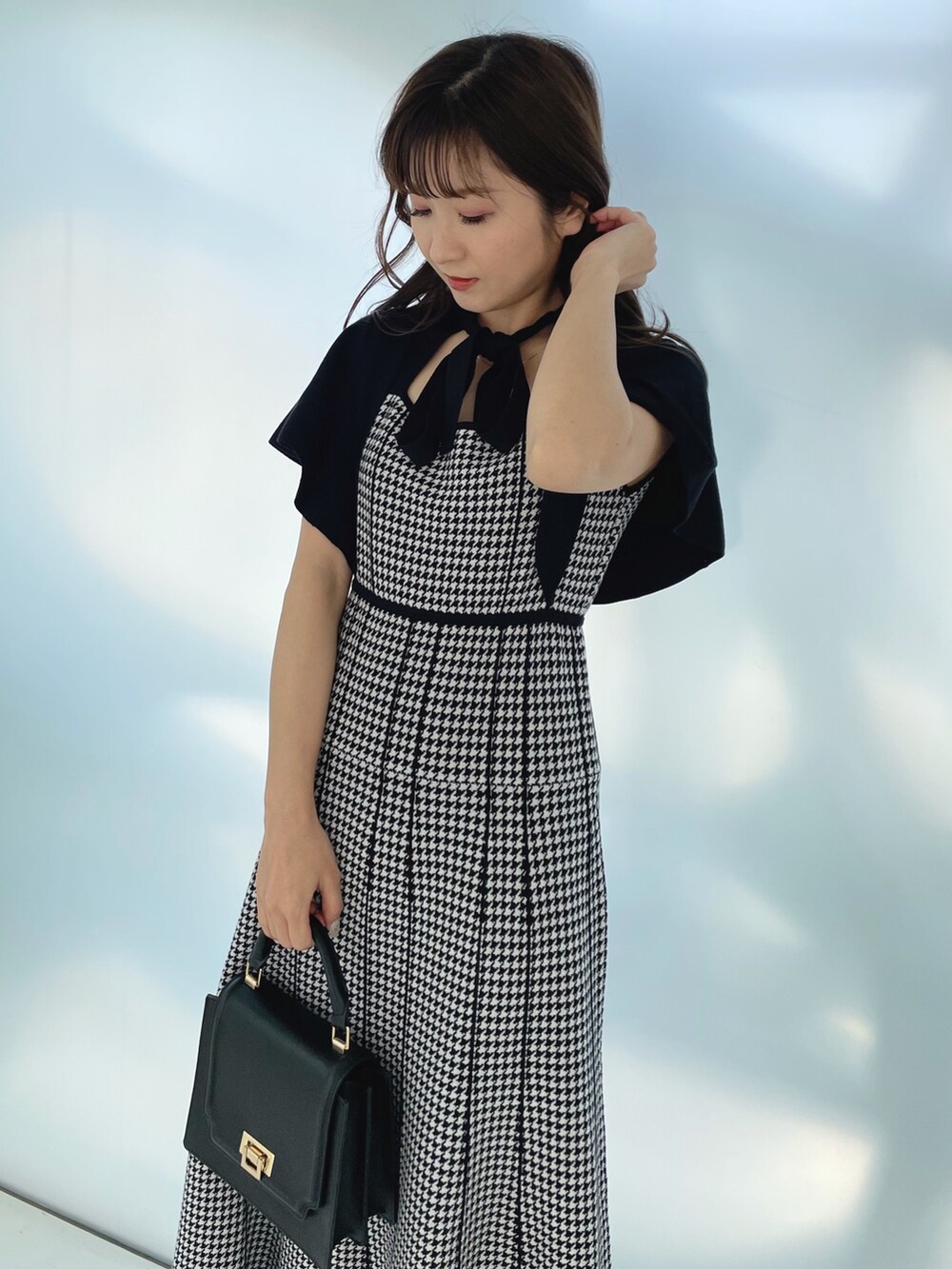 ブラック系のワンピースを着用したレディースの夏コーディネートの2枚目の写真