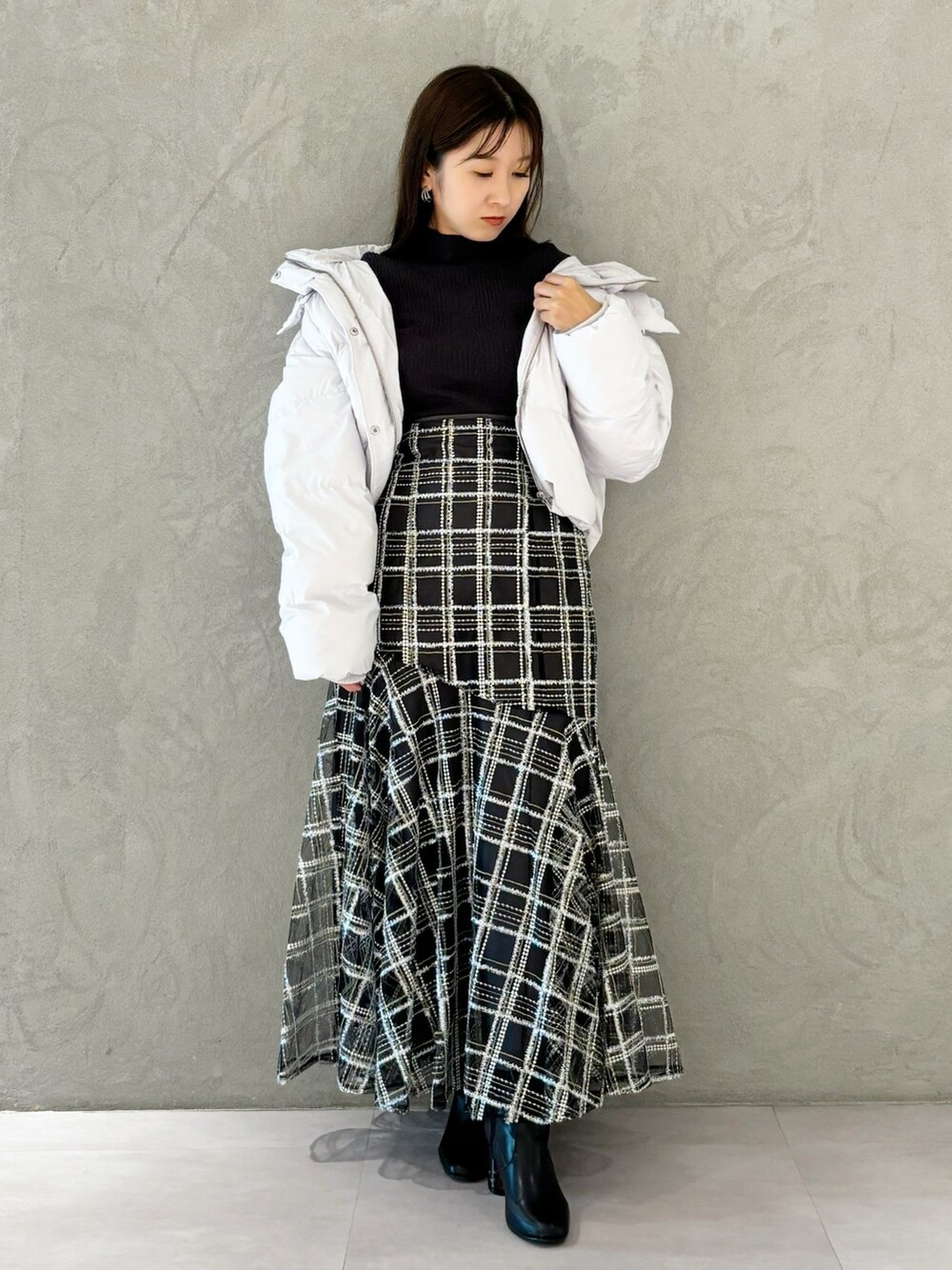 ブラック系のスカート、ブラック系のブーツ、グレー系のニット/セーターを着用したレディースの秋コーディネートの8枚目の写真