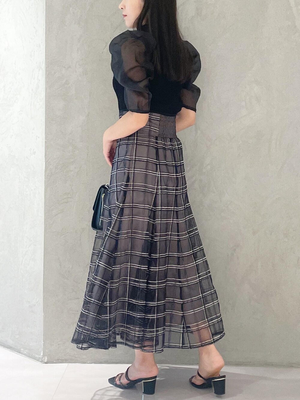 ブラック系のスカート、ブラック系のサンダル、ブラック系のショルダーバッグを着用したレディースの夏コーディネートの4枚目の写真