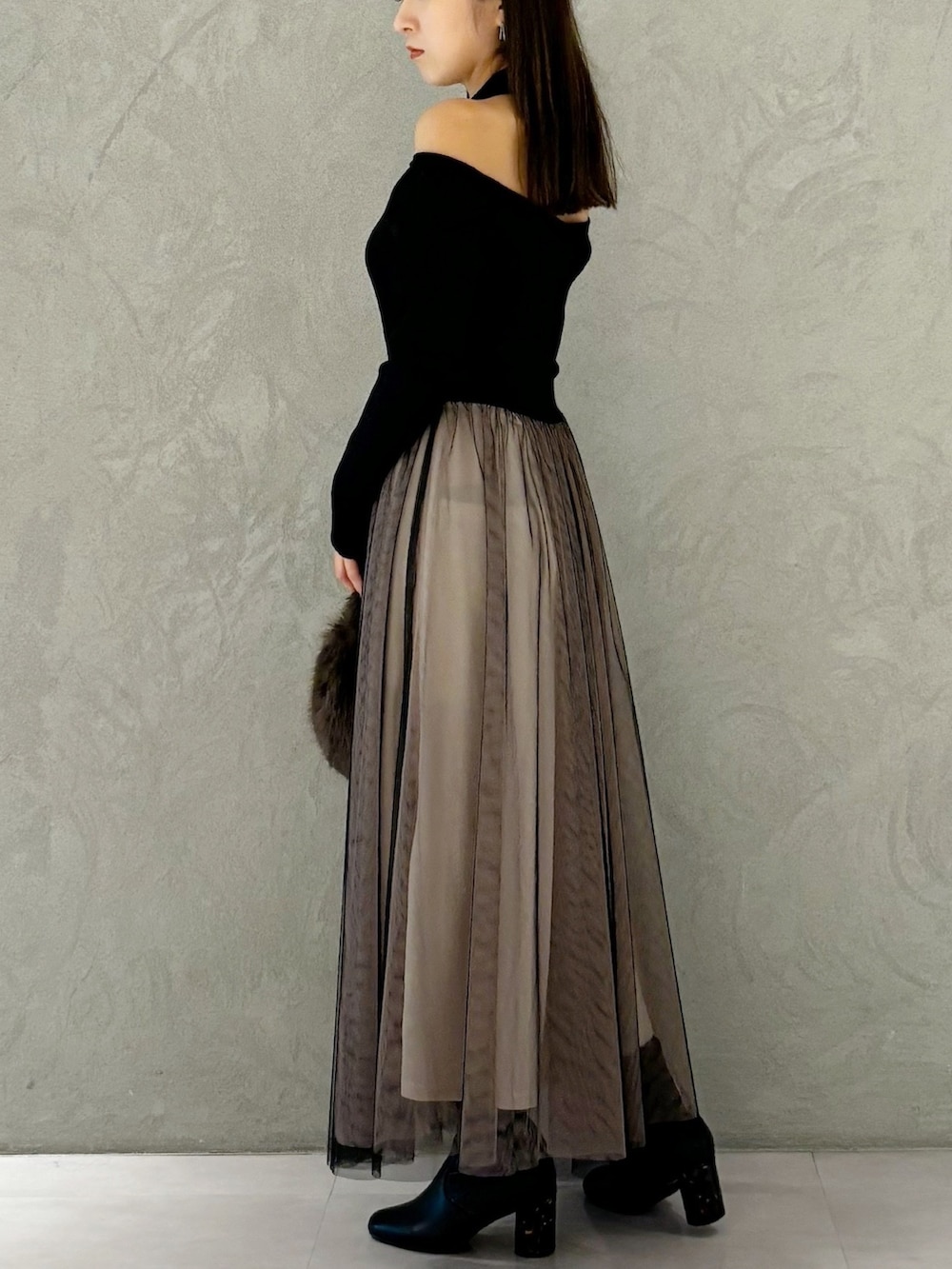 ブラック系のワンピース、ブラック系のブーツ、ブラウン系のハンドバッグを着用したレディースの秋コーディネートの4枚目の写真