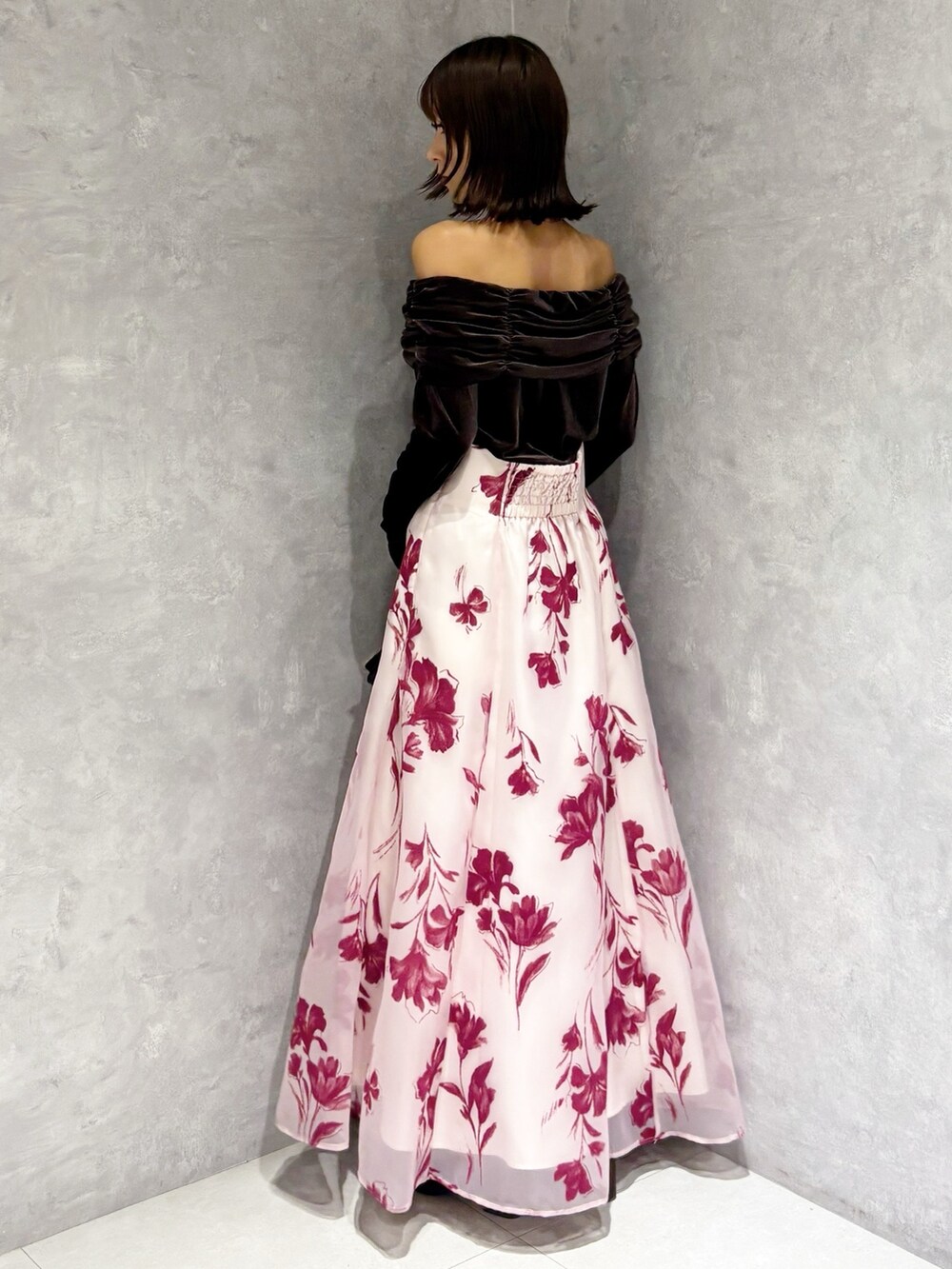 ブラック系のハンドバッグ、ブラウン系のTシャツ/カットソー、ピンク系のスカートを着用したレディースの秋コーディネートの2枚目の写真