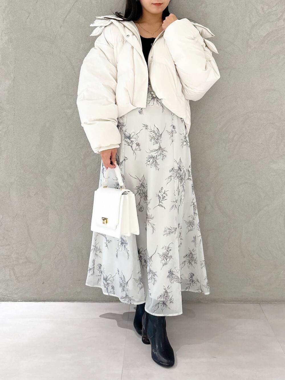 ブラック系のワンピース、ブラック系のブーツ、ホワイト系のハンドバッグを着用したレディースの秋コーディネートの9枚目の写真