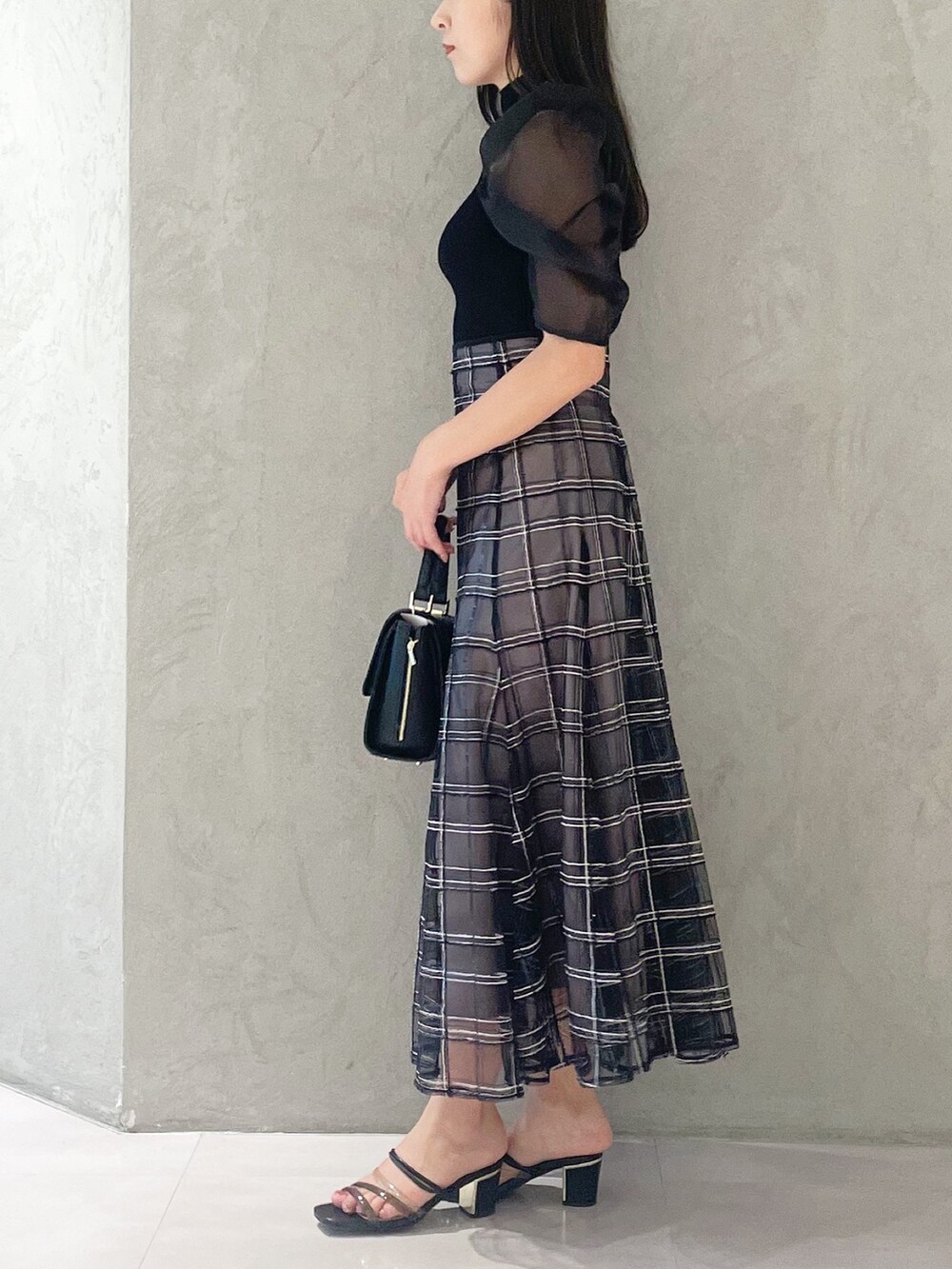 ブラック系のスカート、ブラック系のサンダル、ブラック系のショルダーバッグを着用したレディースの夏コーディネートの3枚目の写真