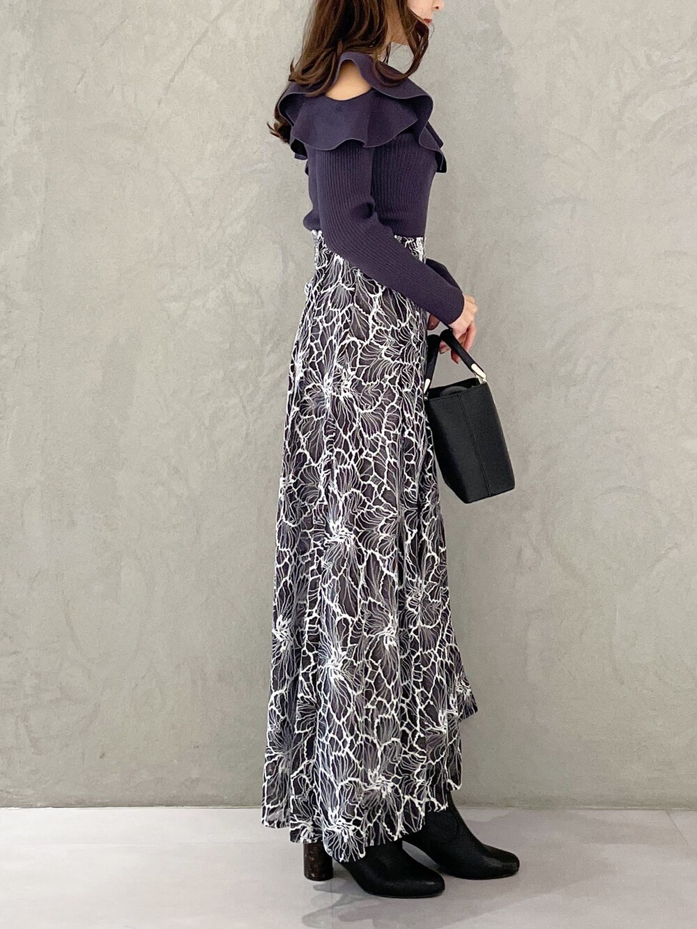 グレー系のスカート、ブラック系のブーツ、ブラック系のハンドバッグを着用したレディースの冬コーディネートの5枚目の写真