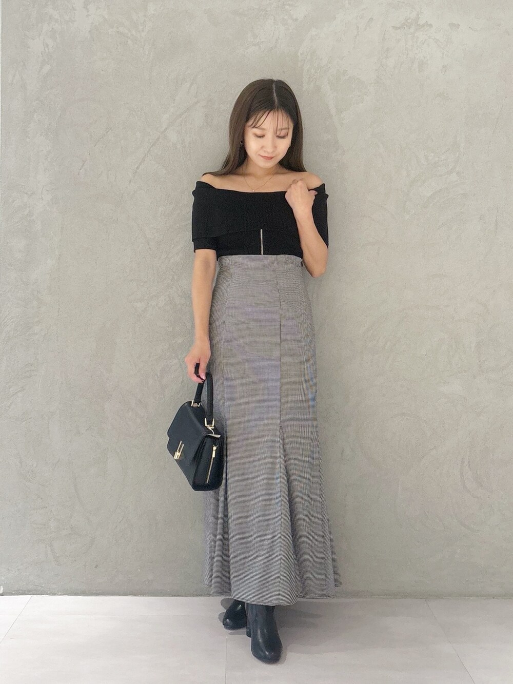 その他のスカート、ブラック系のブーツ、ブラック系のショルダーバッグを着用したレディースの秋コーディネートの4枚目の写真