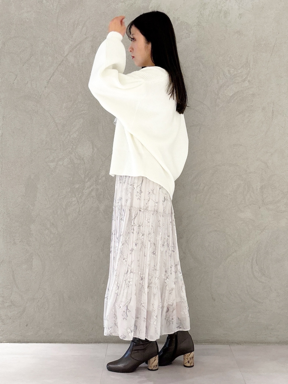 ピンク系のワンピース、ブラウン系のブーツ、ブラウン系のハンドバッグを着用したレディースの冬コーディネートの2枚目の写真