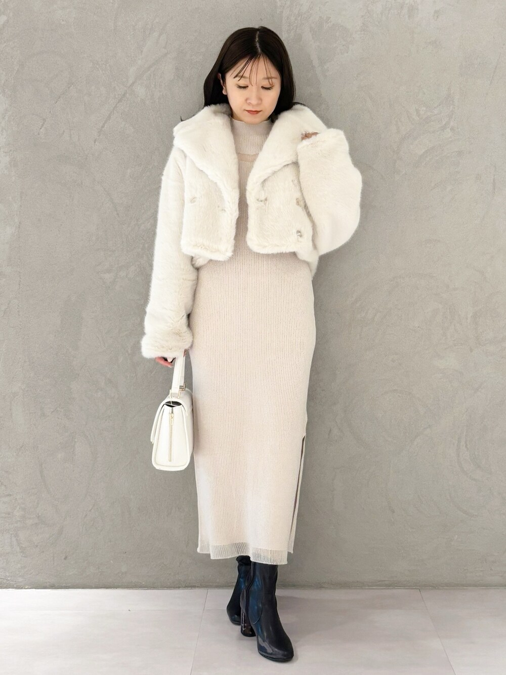 ホワイト系のワンピース、ブラック系のブーツ、ホワイト系のハンドバッグを着用したレディースの冬コーディネートの8枚目の写真