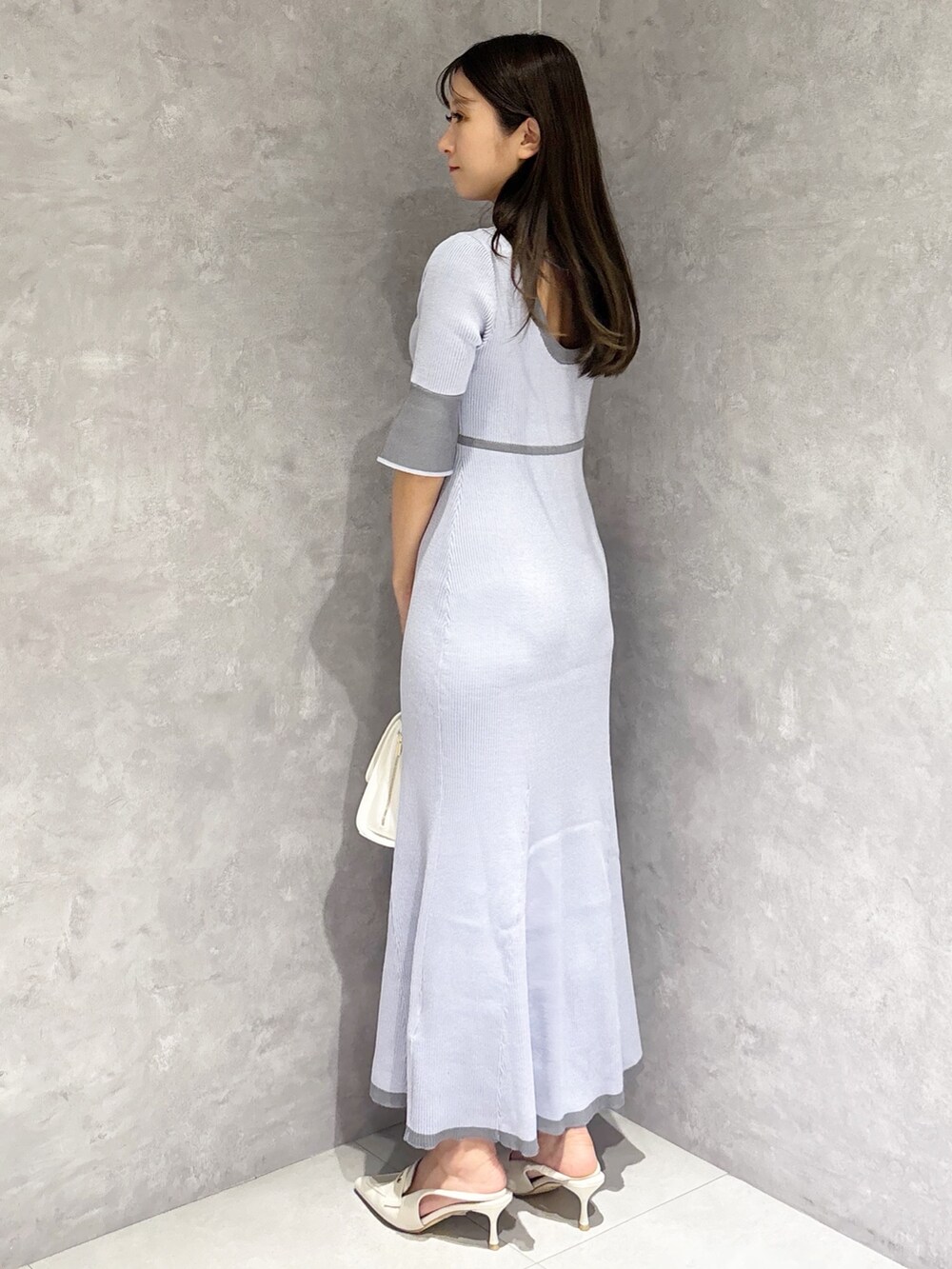 ブルー系のワンピース、ホワイト系のパンプス、ホワイト系のハンドバッグを着用したレディースの春コーディネートの4枚目の写真