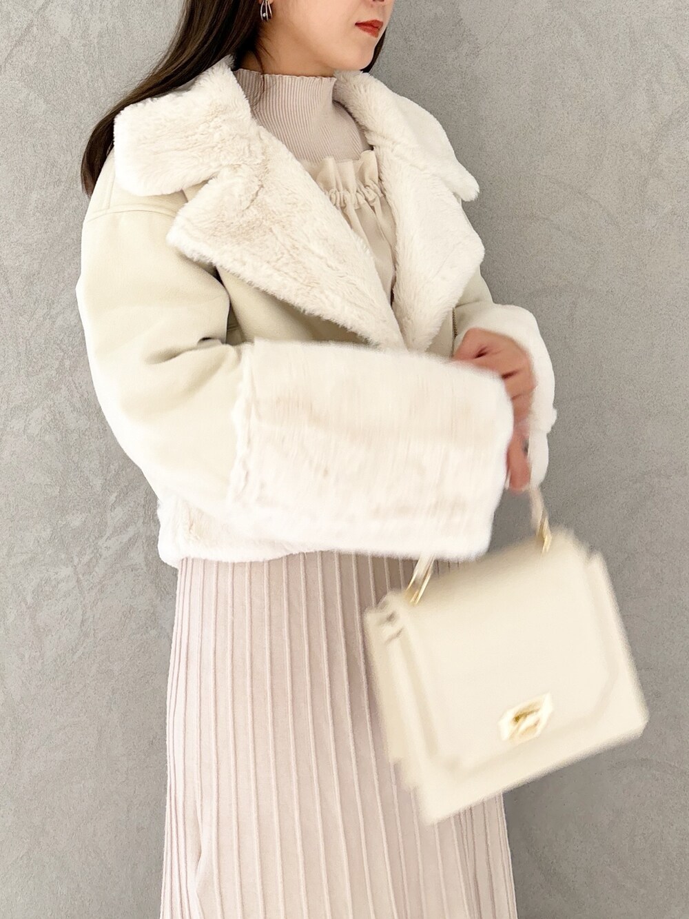 ホワイト系のワンピース、ブラック系のブーツ、ホワイト系のハンドバッグを着用したレディースの秋コーディネートの5枚目の写真