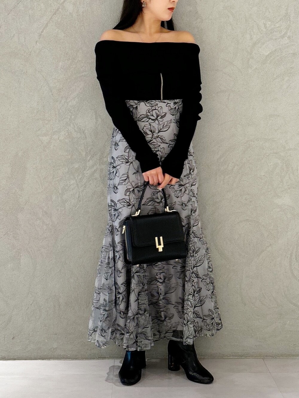 グレー系のスカート、ブラック系のブーツ、ブラック系のショルダーバッグを着用したレディースの秋コーディネートの8枚目の写真