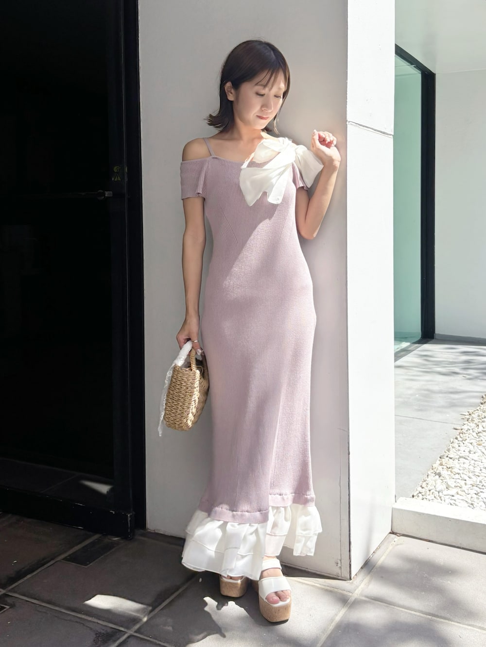 ピンク系のワンピース、ベージュ系のハンドバッグ、ホワイト系のサンダルを着用したレディースの夏コーディネートの8枚目の写真