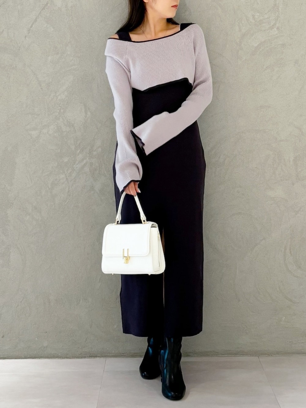 グレー系のワンピース、ブラック系のブーツ、ホワイト系のハンドバッグを着用したレディースの秋コーディネートの6枚目の写真