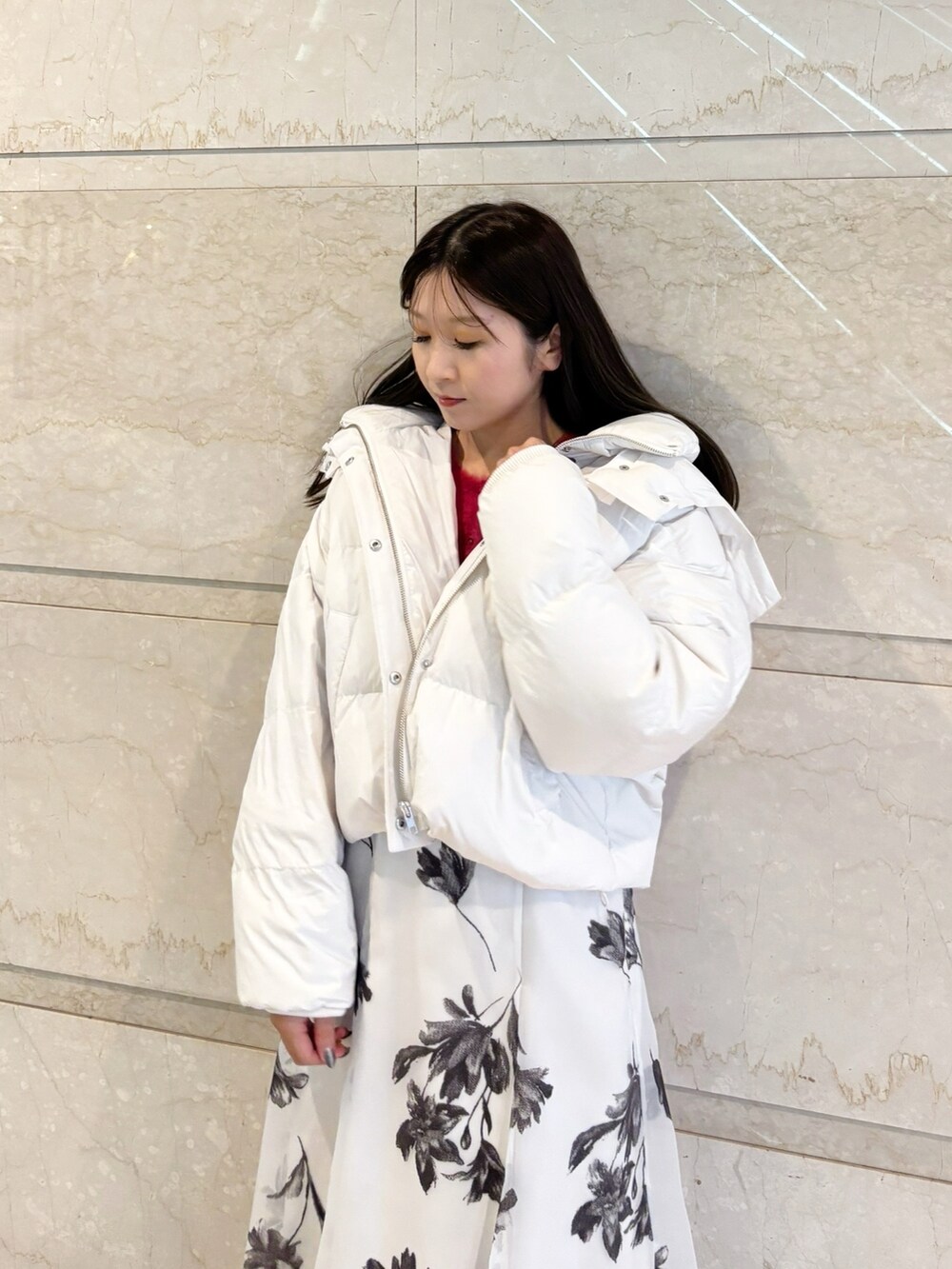 ホワイト系のスカート、ブラック系のブーツ、レッド系のカーディガン/ボレロを着用したレディースの冬コーディネートの3枚目の写真