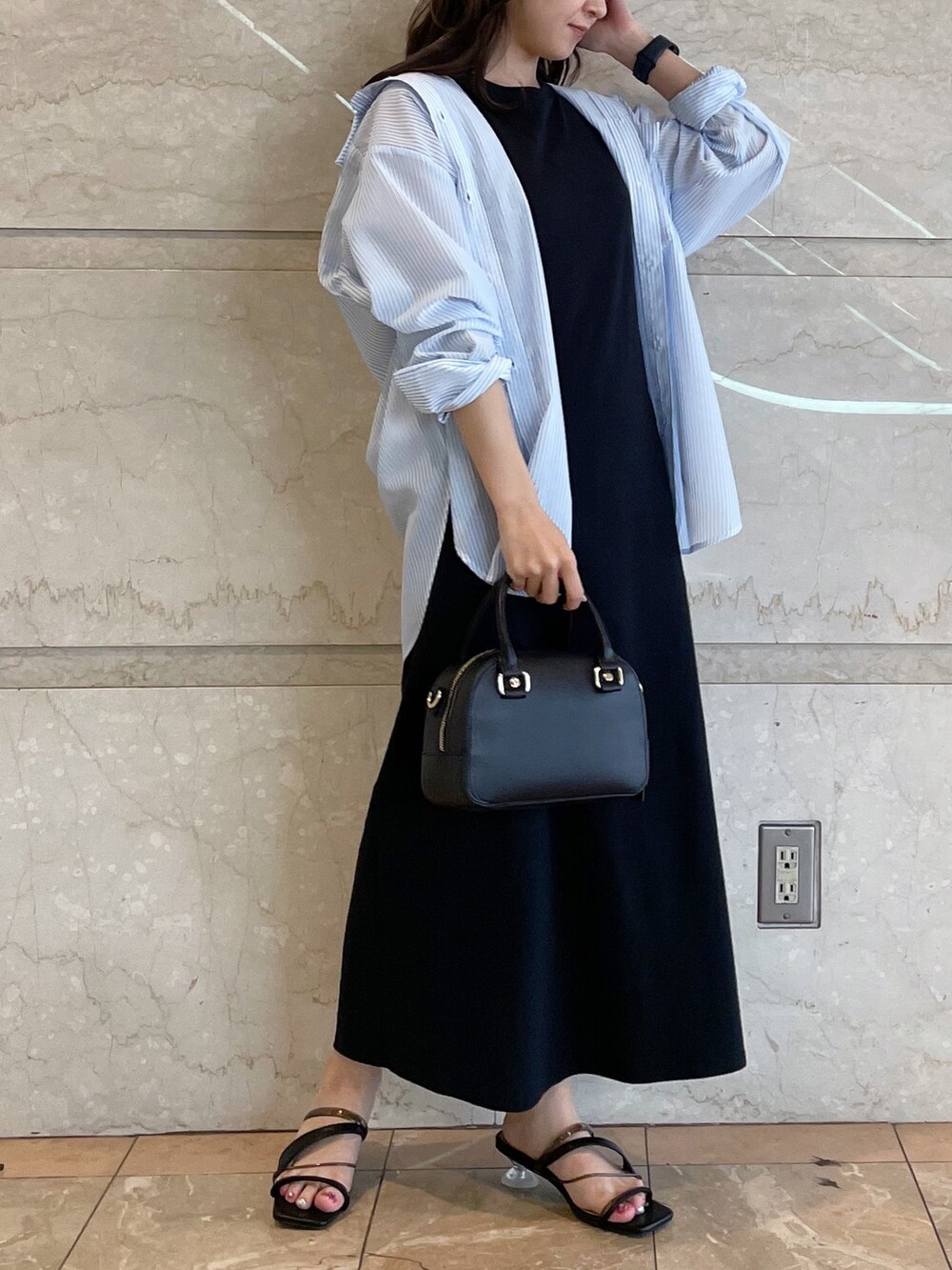 ホワイト系のボストンバッグ、ブラック系のサンダル、ブルー系のシャツ/ブラウスを着用したレディースの春コーディネートの3枚目の写真