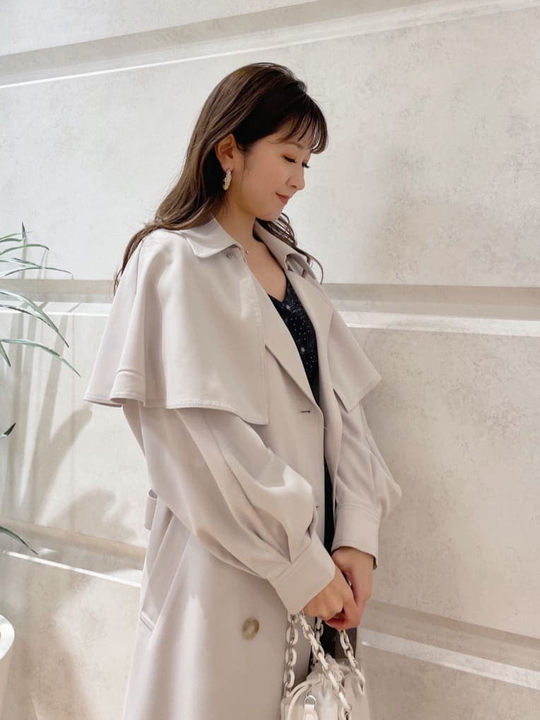 ブラック系のワンピース、ブラック系のその他シューズ、グレー系のトレンチコートを着用したレディースの冬コーディネートの3枚目の写真