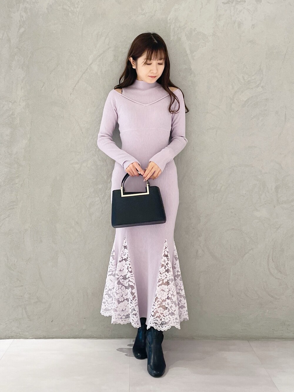 ピンク系のワンピース、ブラック系のブーツ、ブラック系のハンドバッグを着用したレディースの冬コーディネートの5枚目の写真