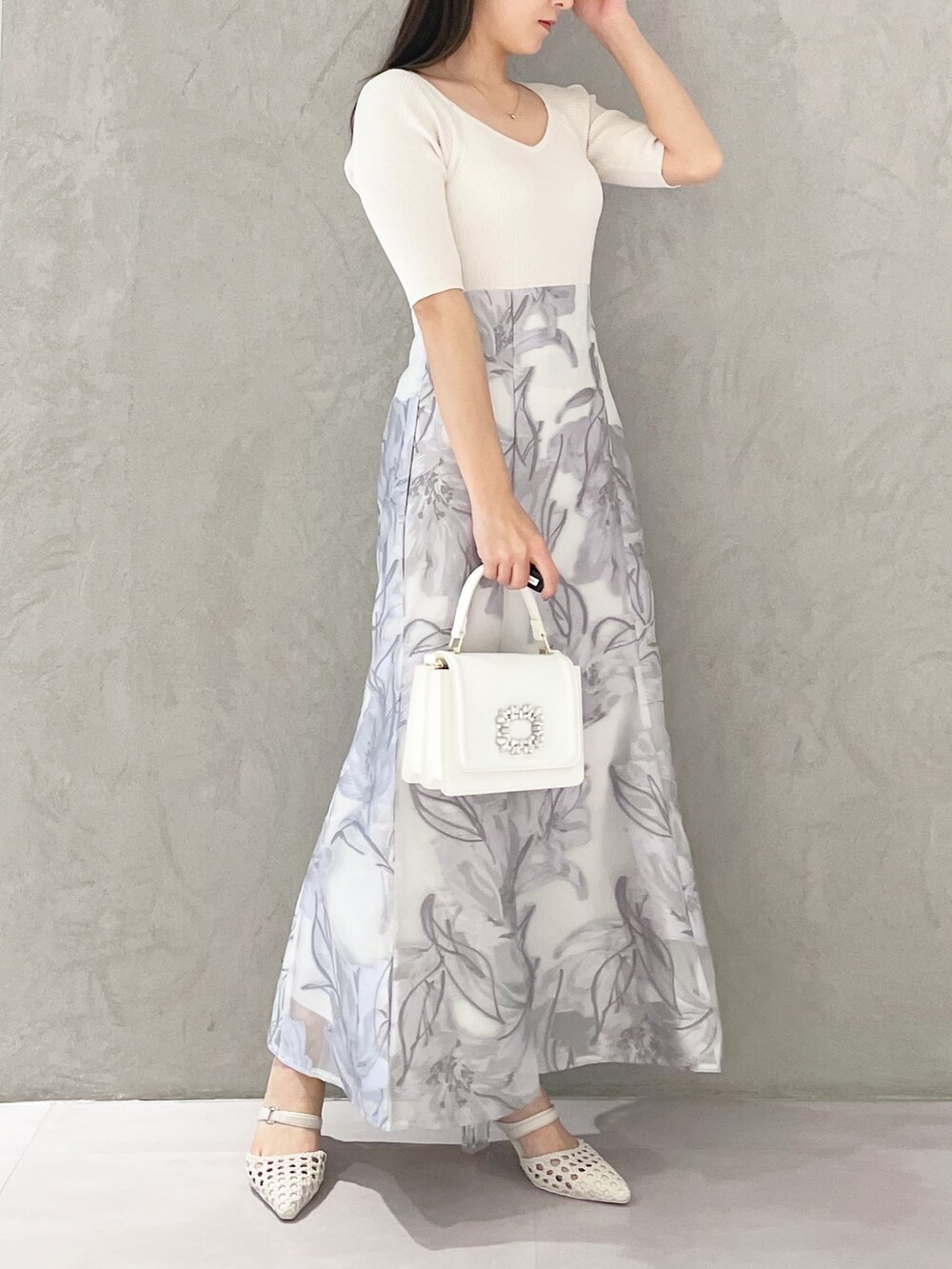 ホワイト系のショルダーバッグ、ホワイト系のパンプス、パープル系のワンピースを着用したレディースの春コーディネートの3枚目の写真