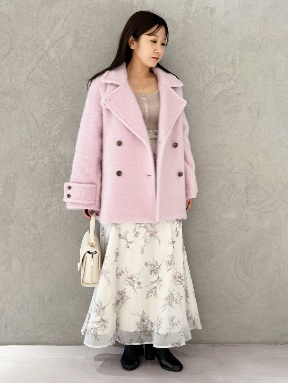 ベージュ系のワンピース、ブラック系のブーツ、ホワイト系のハンドバッグを着用したレディースの冬コーディネートの8枚目の写真