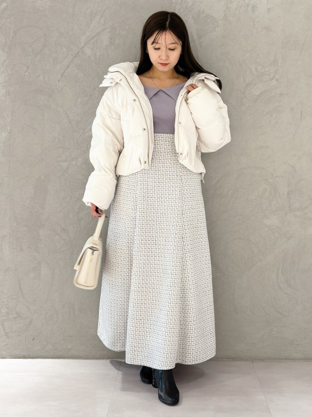 ホワイト系のスカート、ブラック系のブーツ、ホワイト系のハンドバッグを着用したレディースの冬コーディネートの8枚目の写真