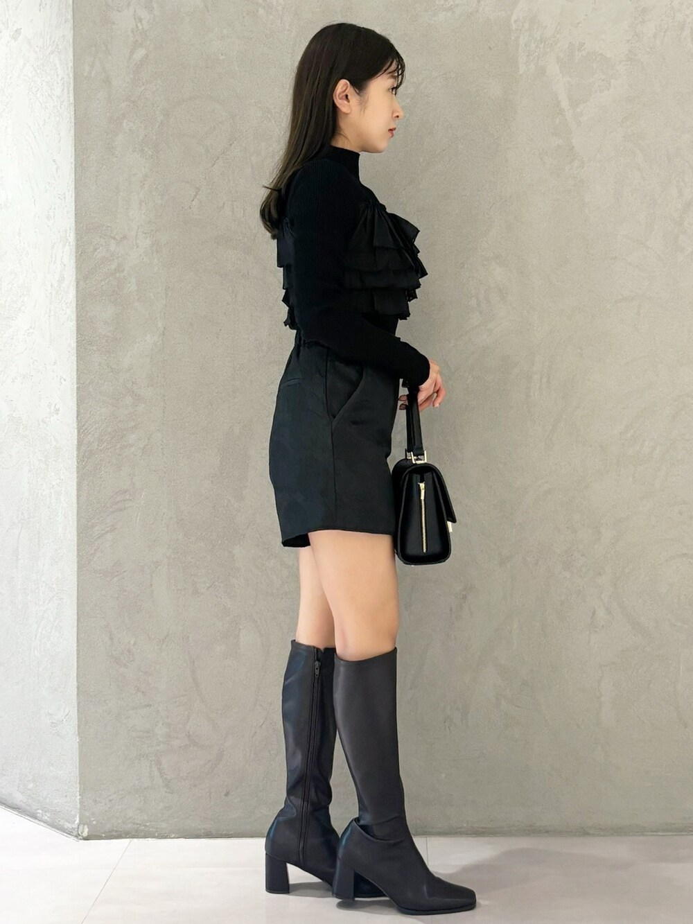 ブラック系のブーツ、ブラック系のショルダーバッグ、ブラック系のニット/セーターを着用したレディースの秋コーディネートの4枚目の写真