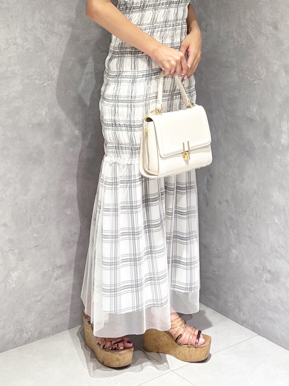 ホワイト系のワンピース、ブラウン系のサンダル、ホワイト系のハンドバッグを着用したレディースの夏コーディネートの5枚目の写真