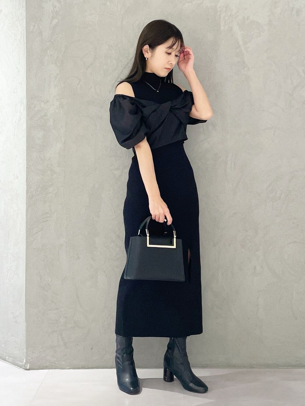 ブラック系のハンドバッグ、ブラック系のブーツ、ブラック系のワンピースを着用したレディースの春コーディネートの5枚目の写真