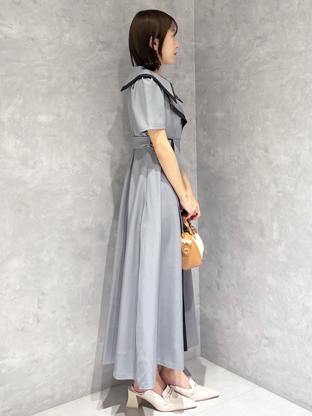 グレー系のワンピース、ホワイト系のパンプスを着用したレディースの春コーディネートの4枚目の写真