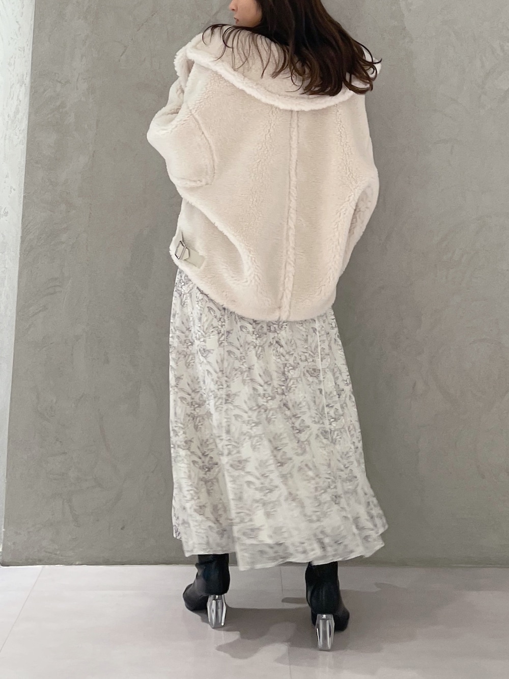 ホワイト系のワンピース、ホワイト系のその他アウター、ブラック系のブーツを着用したレディースの秋コーディネートの3枚目の写真