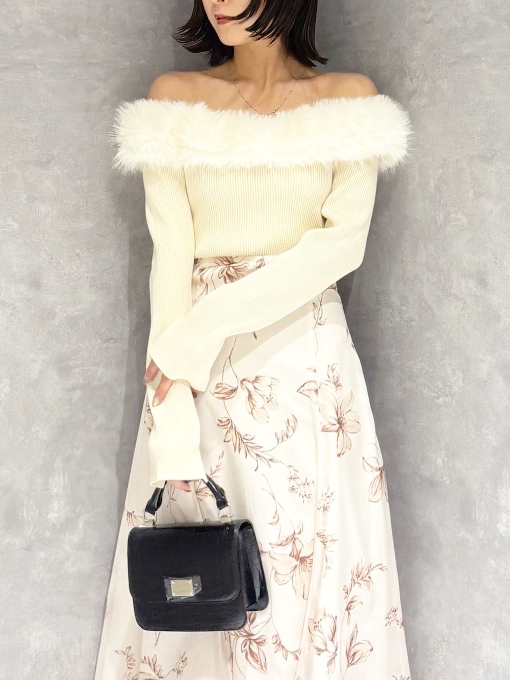 ホワイト系のワンピース、ブラウン系のブーツ、ブラック系のハンドバッグを着用したレディースの冬コーディネートの5枚目の写真