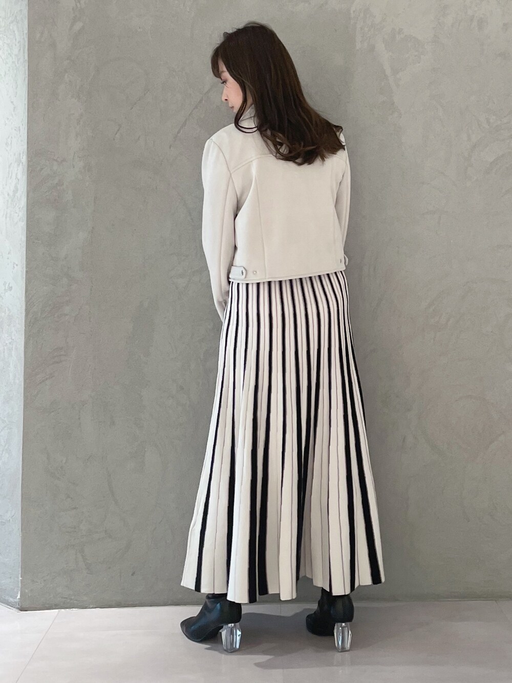 ホワイト系のワンピース、ピンク系のライダースジャケット、ホワイト系のハンドバッグを着用したレディースの春コーディネートの4枚目の写真