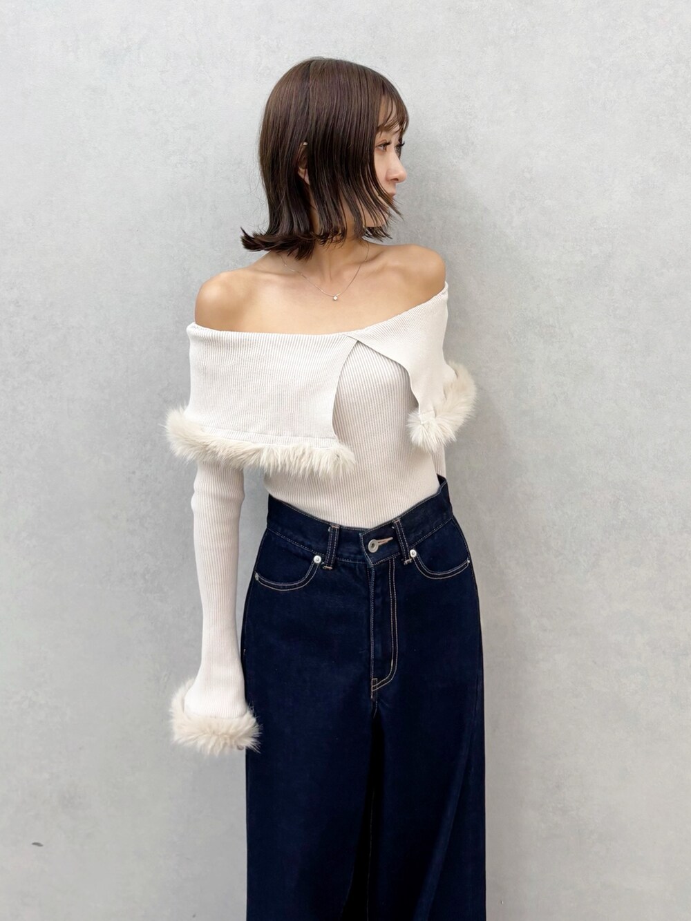 ブルー系のデニムパンツ、ブラウン系のブーツ、ベージュ系のニット/セーターを着用したレディースの秋コーディネートの8枚目の写真
