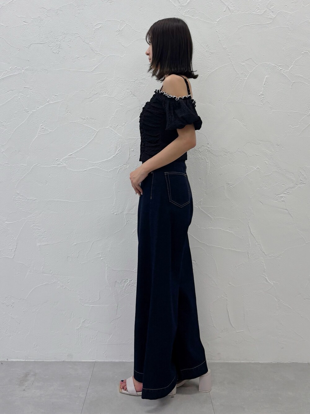 ブルー系のデニムパンツ、ホワイト系のサンダル、ブラック系のTシャツ/カットソーを着用したレディースの夏コーディネートの7枚目の写真