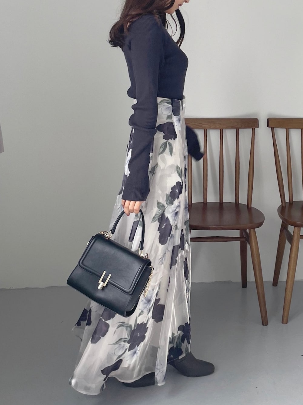 ブルー系のスカート、ブラウン系のブーツ、ブラック系のショルダーバッグを着用したレディースの秋コーディネートの3枚目の写真