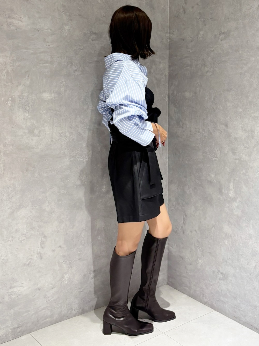 ブラック系のその他パンツ、ブラウン系のブーツ、ブルー系のシャツ/ブラウスを着用したレディースの秋コーディネートの4枚目の写真